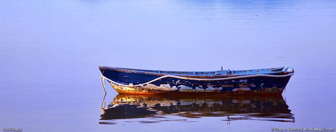 Old Dinghy sits in ocean off East Sullivan, Maine