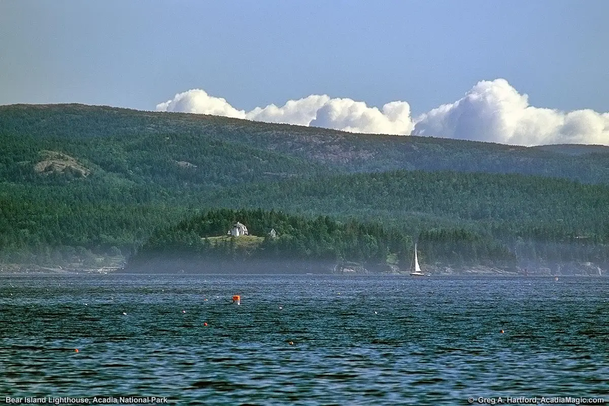 Cadillac Mountain of Acadia National Park towers over Bear Island Lighthouse.
