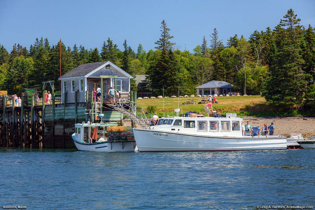 People disembark a boat at a dock is Islesford, Maine.