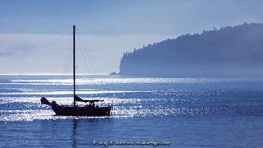 Sailboat in Bar Harbor, Maine with sunlight sparkles in the water